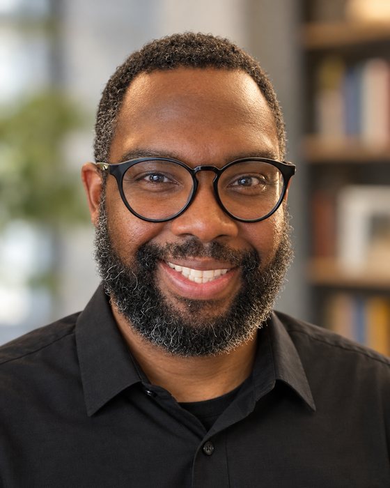Brandon Mayes, a Texas fourth-grade teacher, smiling in front of a bookshelf.